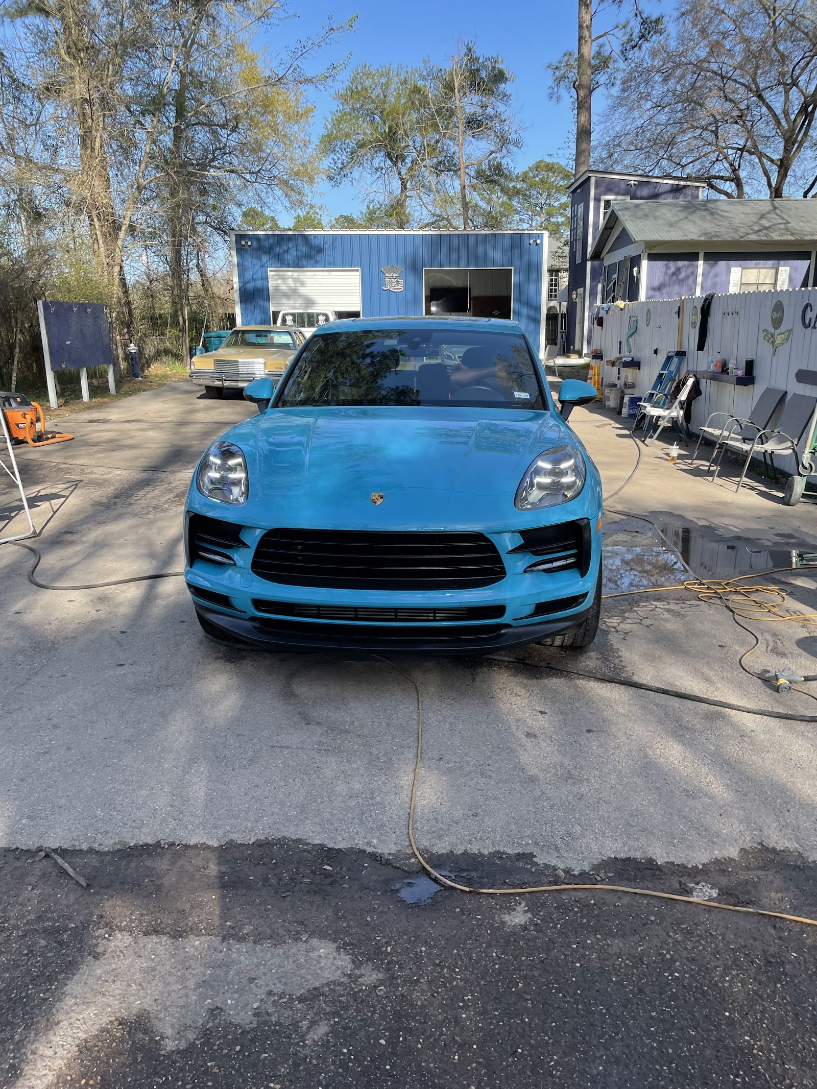 Porsche Macan at BK's Hand Car Wash, with shop signage